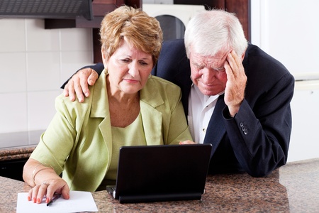 unhappy senior couple worrying about expenses at homeの写真素材