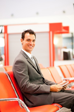 happy young businessman using tablet at airport の写真素材