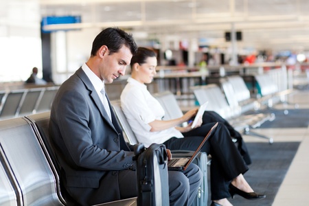 businessman and businesswoman using laptop and tablet computer at airportの写真素材