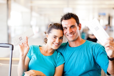 happy young couple with boarding pass at airportの写真素材