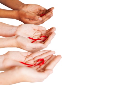 hands holding red ribbon to rise AIDS HIV awarenessの写真素材