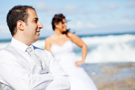 groom and bride on beach rocks の写真素材