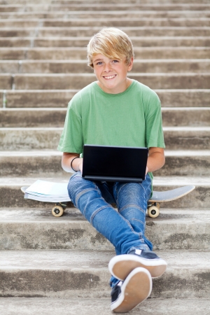 cute teen boy with laptop outdoorsの写真素材