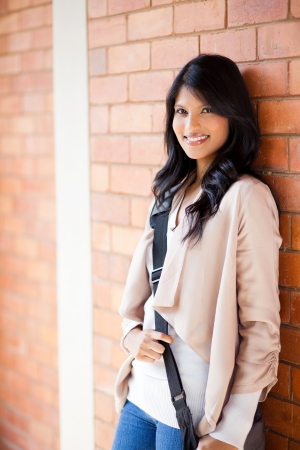 attractive female college student standing by the wallの写真素材