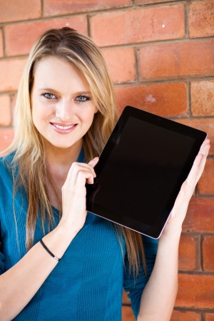 beautiful female college student presenting tablet computer の写真素材