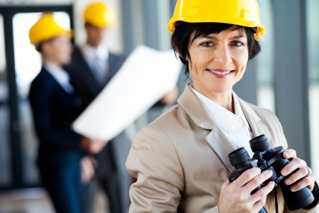 elegant middle aged female architect with binocularsの写真素材