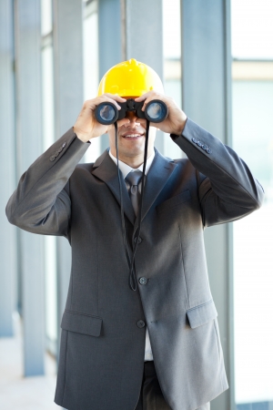 young male construction manager using binocularsの写真素材