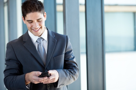 happy businessman reading emails from a smart phoneの写真素材
