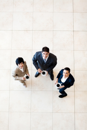 overhead view of colleagues having coffee break at workの写真素材