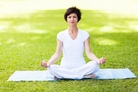 elegant middle aged woman doing yoga meditationの写真素材