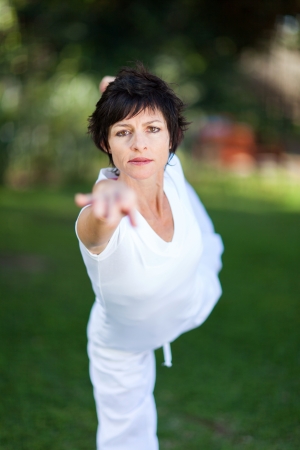 elegant mature woman doing yoga outdoors in forestの写真素材