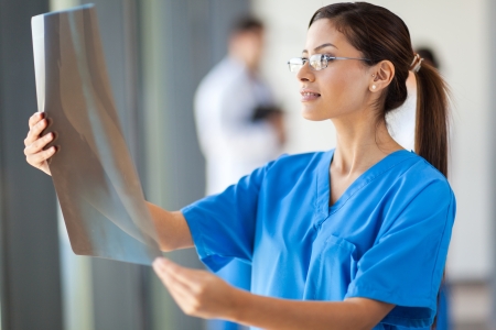 young attractive medical worker looking at x-ray filmの写真素材
