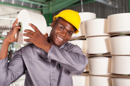 textile factory worker carrying raw material on his shoulderの写真素材