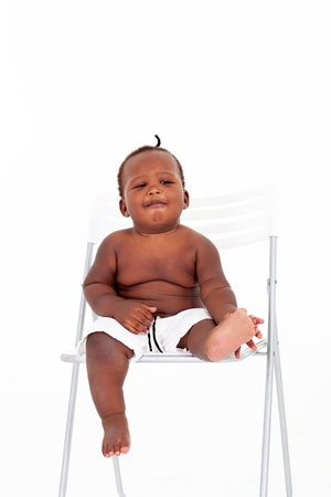 cute african american baby boy sitting on white chairの写真素材