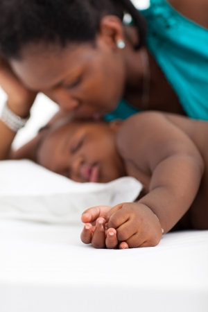 african american mother kissing sleeping babyの写真素材