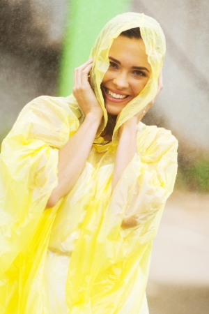 pretty woman dress in raincoat having fun in the rainの写真素材