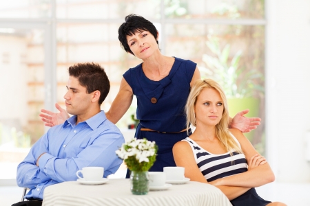 middle aged mother feeling helpless when caught in between young couple's fightの写真素材