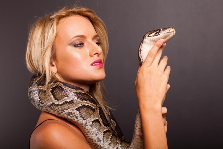 pretty young woman holding python の写真素材