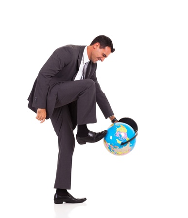 young businessman turning globe with his foot isolated on whiteの写真素材