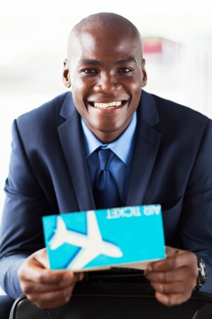 handsome african businessman holding air ticketの写真素材