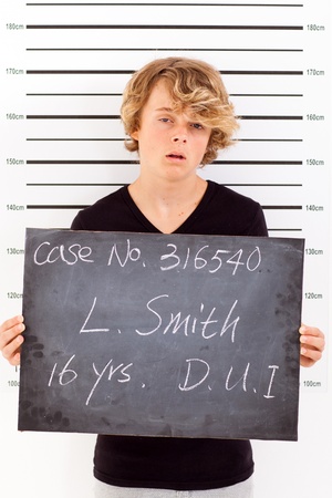 teen boy get arrested for drunk driving and taking police mug shotの写真素材