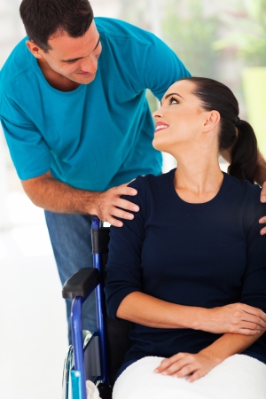 loving husband talking to handicapped wife at homeの写真素材