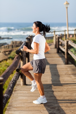 healthy mature woman doing exercise at beach in the morningの写真素材