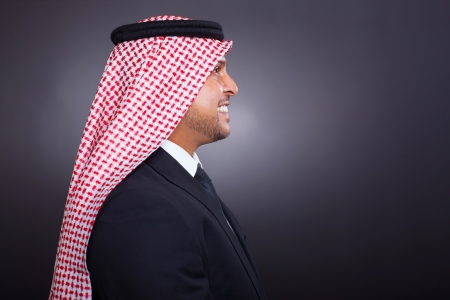 side view of smiling arabian man in black suitの写真素材