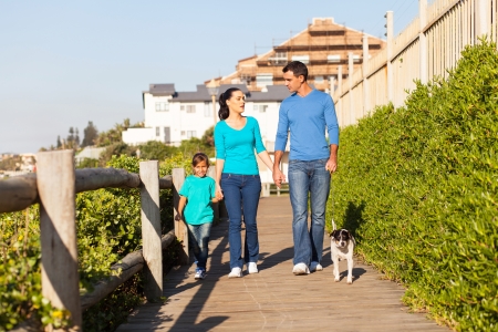 beautiful modern family walking their dog at the beachの写真素材