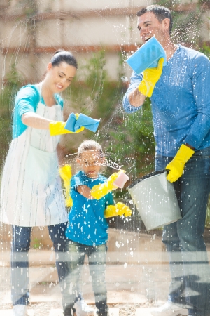 happy young family cleaning home window glassの写真素材