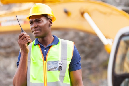 african american mine worker with walkie-talkie at mining siteの写真素材