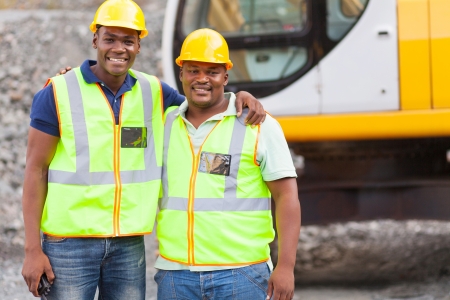 african industrial co-workers portrait in front of machineの写真素材