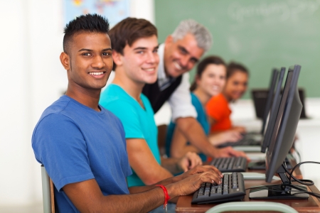 group of students and teacher in computer class looking at the cameraの写真素材