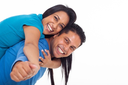 happy young indian couple having fun with piggyback on white backgroundの写真素材