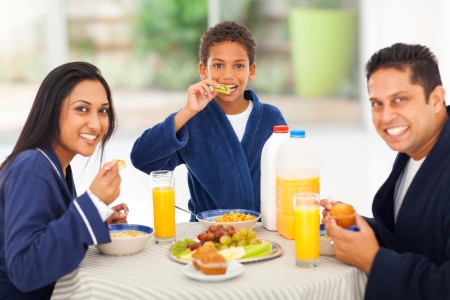 cheerful cute indian family enjoying their breakfast togetherの写真素材
