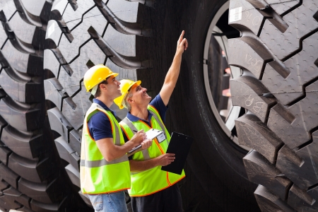 shipping company workers checking industrial tires before exportingの写真素材