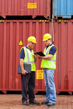 harbor inspectors standing next to containers at depotの写真素材