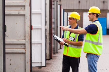 smiling warehouse workers checking open containers before loadingの写真素材