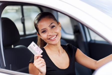 cheerful young woman showing a driving licence she just gotの写真素材