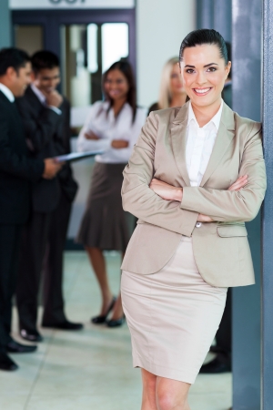 beautiful businesswoman standing in office with colleagues on backgroundの写真素材