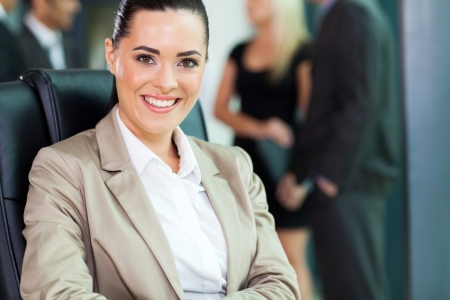 attractive young businesswoman closeup portrait with co-workers on backgroundの写真素材
