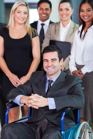 happy businessman in wheelchair with colleaguesの写真素材