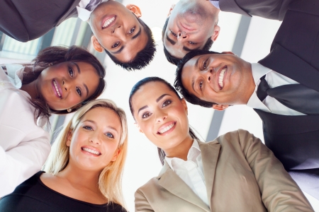 group of business people in a circle looking down group of business people in a circle looking down