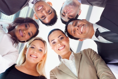 group of business people in a circle looking down