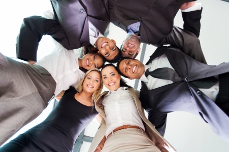 underneath view of business people in a circle looking downの写真素材