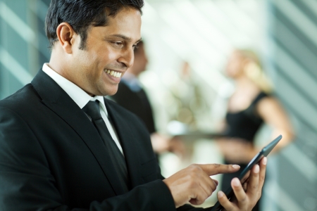 handsome indian business executive working on tablet computer in officeの写真素材