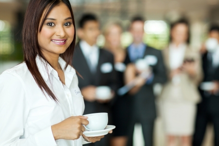 beautiful young indian woman drinking coffee during seminar breakの写真素材