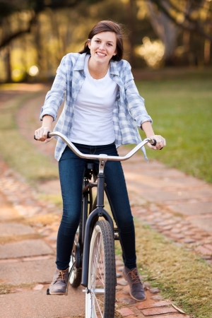 beautiful teenage girl riding bike outdoorsの写真素材