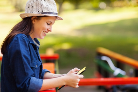 cheerful teenage girl using tablet computer outdoorsの写真素材