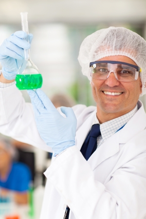 smiling senior medical researcher holding a flask in labの写真素材